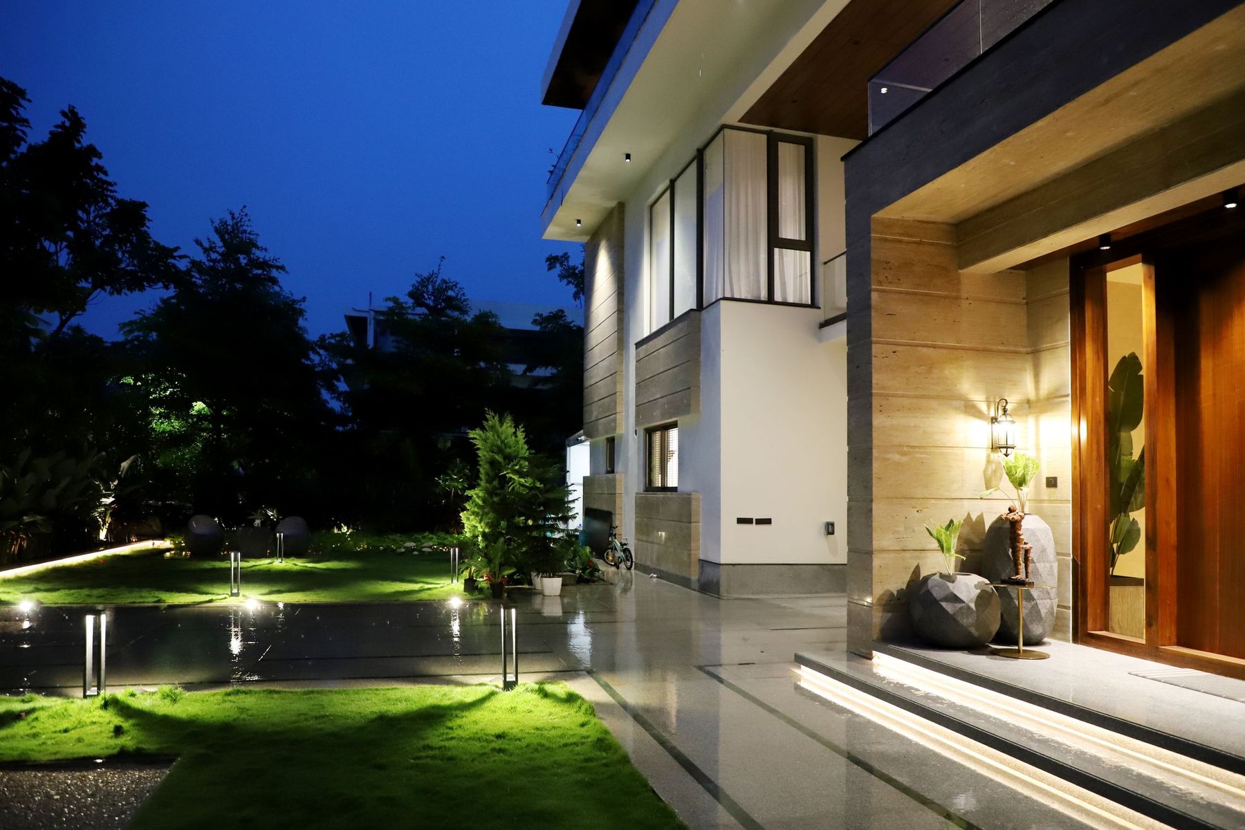 A modern custom home at dusk, warmly lit